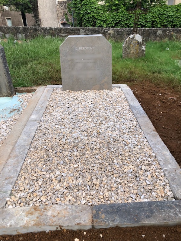 Photo d’un monument funéraire avec stèle et entourage en pierre naturelle